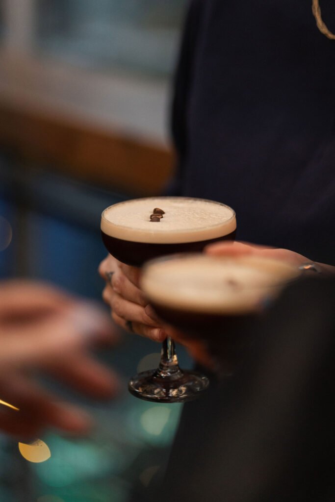 A smooth and frothy espresso martini elegantly held in hand, showcasing its rich coffee colour and perfect crema at Full Circle Brew Co.