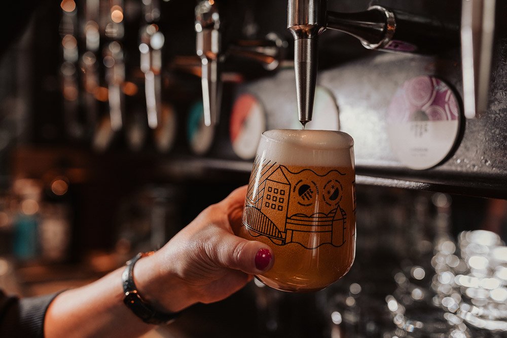 Freshly poured Full Circle Brew Co craft beer flowing from the tap into a North East landscape glass, showcasing its rich colour and perfect frothy head.